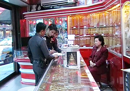 Police officers interview gold shop owner Wantanee Supasaharangsi following the theft at her premises on Wednesday.